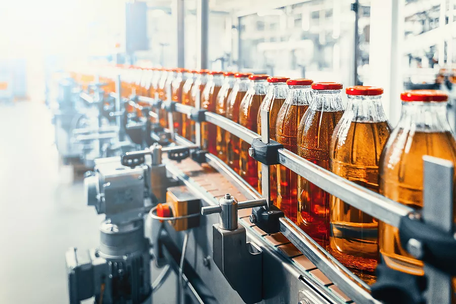 amber colored beverage being bottle on an assembly line 